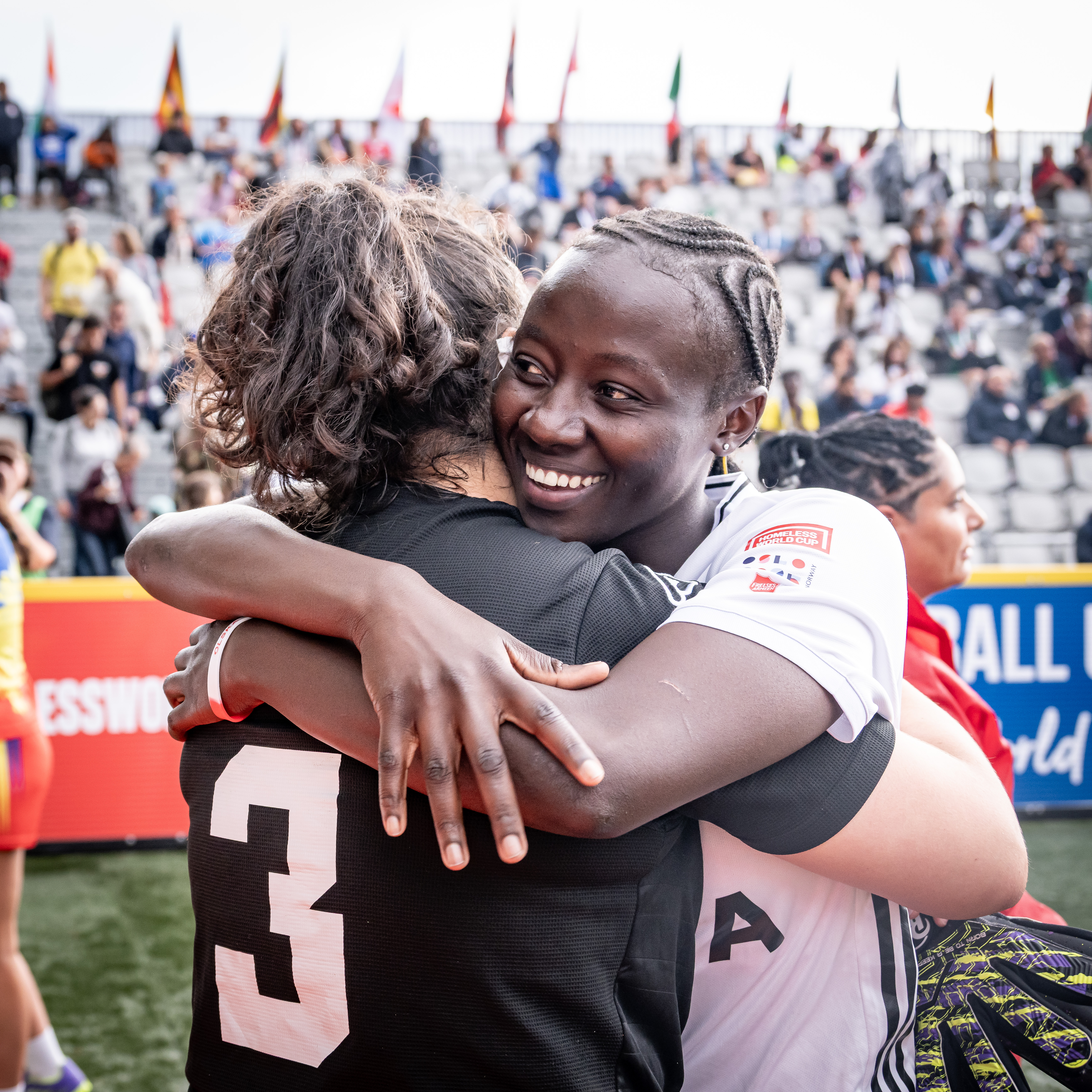 Two football players celebrate with a hug.